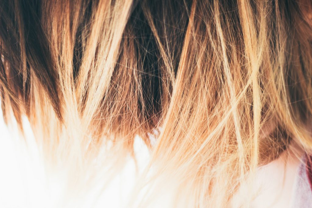Jeune femme aux cheveux colorés avec un balayage blond
