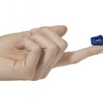 Appareil auditif miniature posé sur le bout d'un doigt