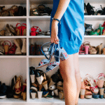 femme en robe bleue se tenant devant un placard plein de chaussures